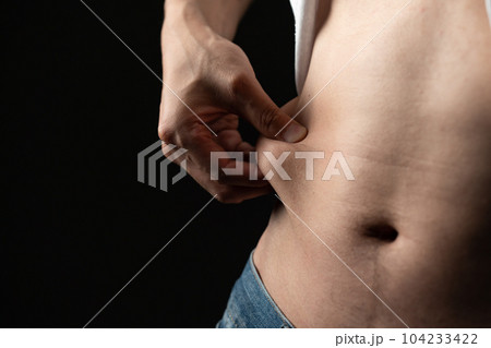 お腹の贅肉をつまむ男性　ダイエット 104233422