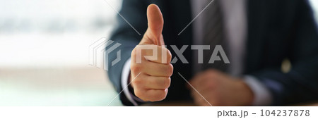 Businessman showing thumb up at work in office closeup 104237878