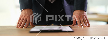 Manager standing at table with documents at business conference closeup Manager standing at table with documents at business conference closeup 104237881