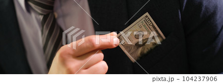 Businessman taking 100 dollar bill out of jacket pocket closeup 104237906