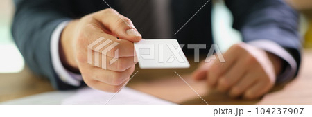 Manager handing out business card to client at work in office closeup Manager handing out business card to client at work in office closeup 104237907