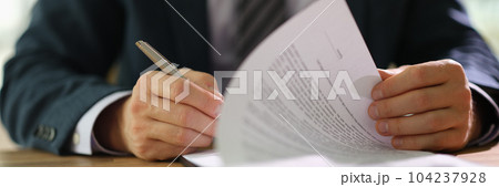 Businessman leafing through documents and signing contract for business deal at work in office closeup Businessman leafing through documents and signing contract for business deal at work in office closeup 104237928