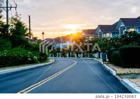 Modern cottages row road sidewalk two story buildings residential villas village New Estate Reflection dawn Sun in windows Modern cottages row road sidewalk two story buildings residential villas village New Estate Reflection dawn Sun in windows 104238063