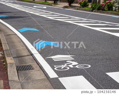 車道の左端に設置された自転車ナビマーク(白色)と自転車ナビライン(青色) 車道の左端に設置された自転車ナビマーク(白色)と自転車ナビライン(青色) 104238146