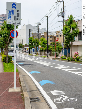 車道の左端に設置された自転車ナビマーク(白色)と自転車ナビライン(青色) 車道の左端に設置された自転車ナビマーク(白色)と自転車ナビライン(青色) 104238148