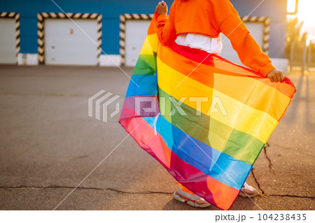 African American lesbian woman holding LGBT rainbow flag. The concept of happiness, freedom and love for same-sex couples. 104238435