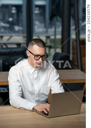 Businessman working online on laptop in cafe. Businessman working online on laptop in cafe. 104238576