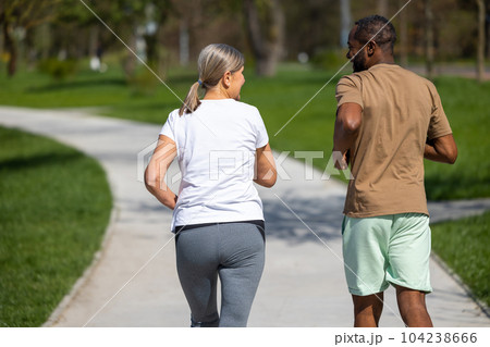 Mature couple jogging in the park together 104238666