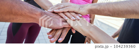 Happy athletes standing in circle with stacked in huddle hands Happy athletes standing in circle with stacked in huddle hands 104239360