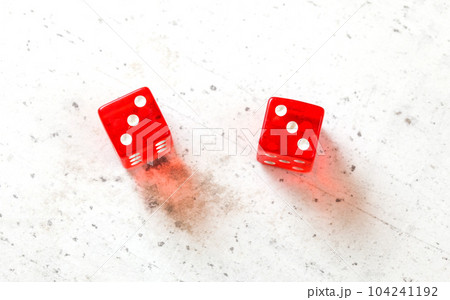 Two red craps dices showing Hard Six (double number three) overhead shot on white board Two red craps dices showing Hard Six (double number three) overhead shot on white board 104241192