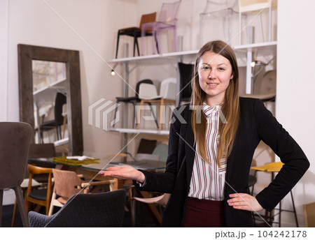 Saleswoman welcoming to chair store 104242178