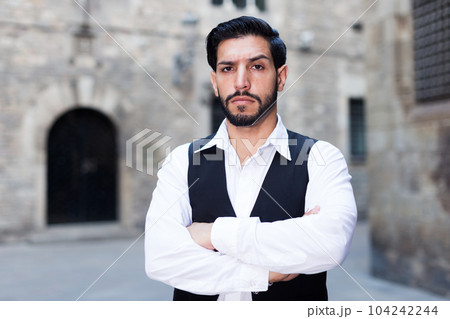 Serious man with arms crossed 104242244