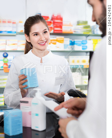 Woman pharmacist is recommending medicine for man client in apothecary. 104242481