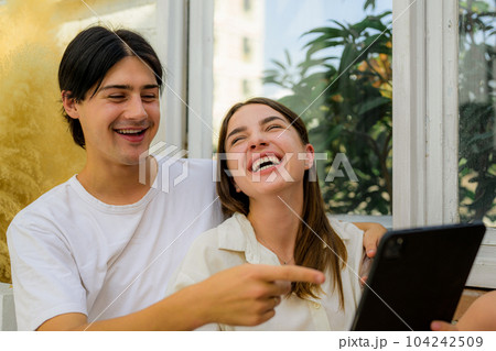 Couple of romantic young people using laptop at home 104242509