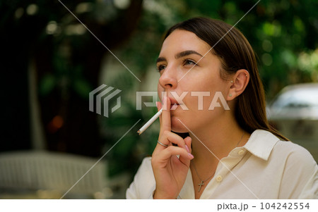 Young couple of man and woman smoking cigarette together Young couple of man and woman smoking cigarette together 104242554