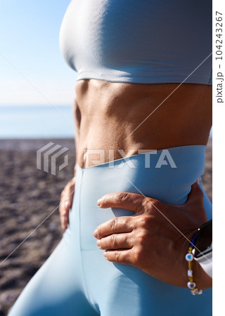 Cropped image of strong fit female body with well- defined abs 104243267