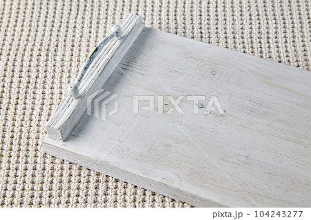 Wooden white tray on the background of a knitted beige plaid 104243277