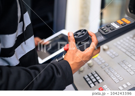 Engineer mechanician operating and controlling CNC machine 104243396