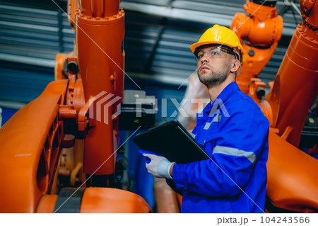 Professional maintenance worker with machine robotic arms at industrial factory Professional maintenance worker with machine robotic arms at industrial factory 104243566