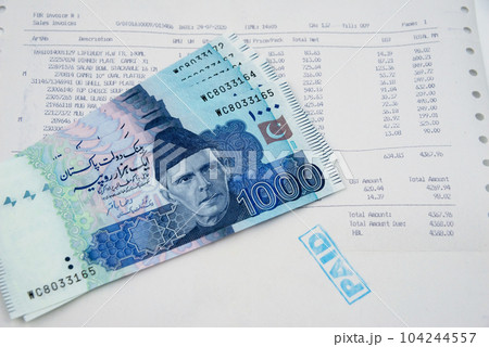 Currency notes in Pakistani Rupees with a paid invoice. 104244557