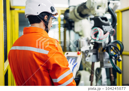 Professional engineer checking and repairing parts of robotic arm 104245077
