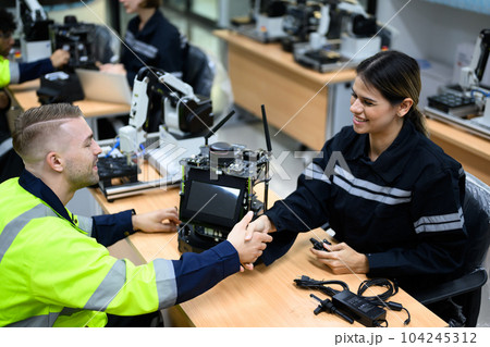 Group of maintenance engineers checking and repairing robotic machine 104245312