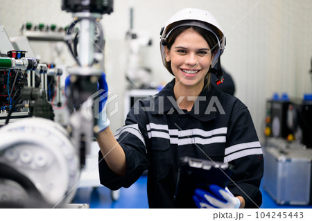 Smiling portrait of female technician checking and repairing machine 104245443
