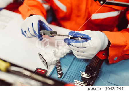 Professional engineer checking and repairing parts of machine 104245444