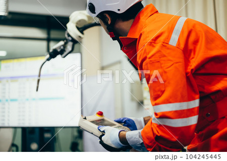 Professional engineer checking and repairing parts of robotic arm 104245445