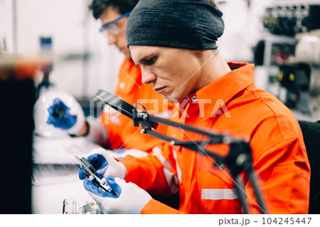 Professional engineer checking and repairing parts of machine 104245447