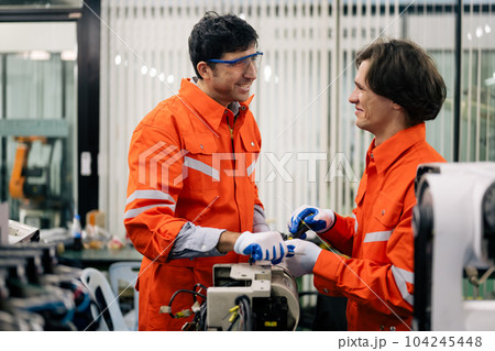 Professional technicians team checking parts of automatic machine 104245448