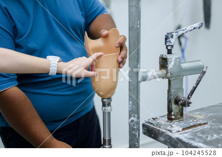 Prosthetic technician holding prosthetic leg checking and controlling Prosthetic technician holding prosthetic leg checking and controlling 104245528