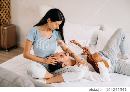 Happy man and woman enjoying with music playing on instrument 104245541