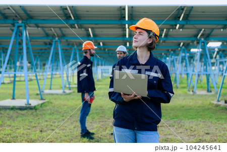 Workers installing solar panels, Engineer team at solar panel farm 104245641