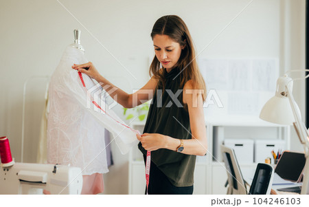Beautiful woman dressmaker working in workshop studio 104246103