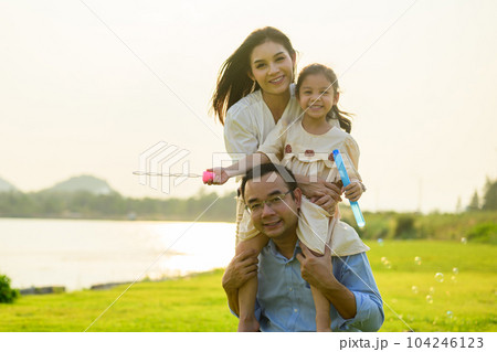 Happy family relaxing and resting in park together on weekend 104246123