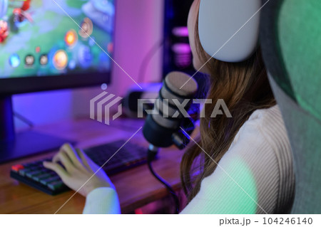 Young female game streamer playing online game on computer at home Young female game streamer playing online game on computer at home 104246140