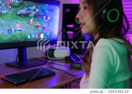 Young female game streamer playing online game on computer at home Young female game streamer playing online game on computer at home 104246210