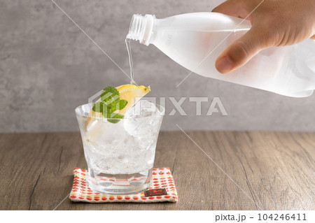 ミントとレモンが入ったロックグラスに炭酸水を注ぐ 炭酸がはじける冷たいグラス ミントとレモンが入ったロックグラスに炭酸水を注ぐ 炭酸がはじける冷たいグラス 104246411