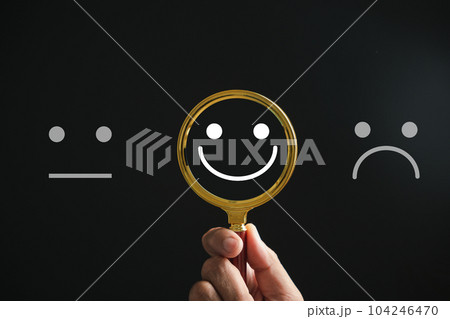 Magnifying glass reveals smiley face, finding happiness amid sadness on black. Customer satisfaction and evaluation after service survey. Magnification, satisfaction, reputation, corporate, customer Magnifying glass reveals smiley face, finding happiness amid sadness on black. Customer satisfaction and evaluation after service survey. Magnification, satisfaction, reputation, corporate, customer 104246470