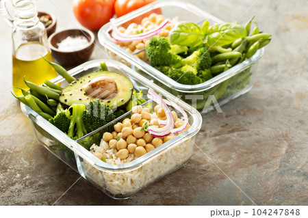 Vegan meal prep containers with cooked rice and chickpeas 104247848