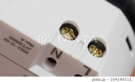 Tightening the socket terminals with a screwdriver. Tightening the socket terminals with a screwdriver. 104248311