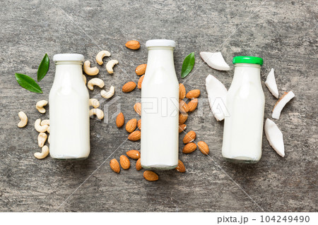 Set or collection of various vegan milk almond, coconut, cashew, on table background. Vegan plant based milk and ingredients, top view 104249490