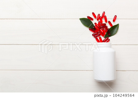 different drugs and health supplement pills poured from a medicine bottle health care and medical top view on colored background different drugs and health supplement pills poured from a medicine bottle health care and medical top view on colored background 104249564