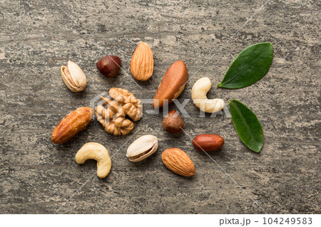 Composition of nuts , flat lay - mix hazelnuts, cashews, almonds on table background. healthy eating concepts and food background Composition of nuts , flat lay - mix hazelnuts, cashews, almonds on table background. healthy eating concepts and food background 104249583