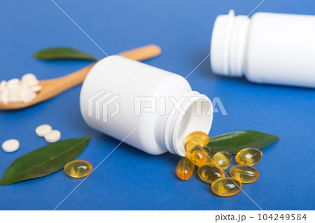 Omega-3 capsules lie in white bottle on a table background. Fish oil tablets top view. Biologically active additives. omega 6, omega 9, vitamin A, E, vitamin D, vitamin D3, evening primrose oil Omega-3 capsules lie in white bottle on a table background. Fish oil tablets top view. Biologically active additives. omega 6, omega 9, vitamin A, E, vitamin D, vitamin D3, evening primrose oil 104249584