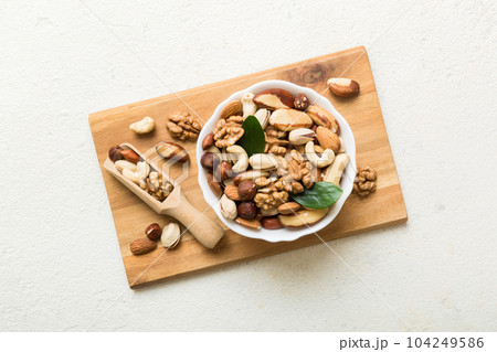 mixed nuts in bowl. Mix of various nuts on colored background. pistachios, cashews, walnuts, hazelnuts, peanuts and brazil nuts mixed nuts in bowl. Mix of various nuts on colored background. pistachios, cashews, walnuts, hazelnuts, peanuts and brazil nuts 104249586