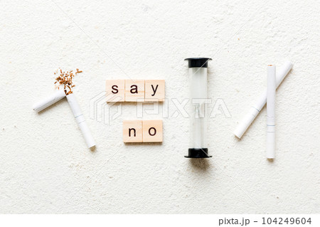 Cigarette And Wooden Blocks, Broken cigarette on table background with hourglass, No Tobacco Day with hourglass, clock health concept. time to quit smoking Cigarette And Wooden Blocks, Broken cigarette on table background with hourglass, No Tobacco Day with hourglass, clock health concept. time to quit smoking 104249604