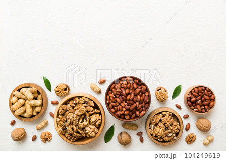 Walnut kernel halves, in a wooden bowl. Close-up, from above on colored background. Healthy eating Walnut concept. Super foods with copy space Walnut kernel halves, in a wooden bowl. Close-up, from above on colored background. Healthy eating Walnut concept. Super foods with copy space 104249619
