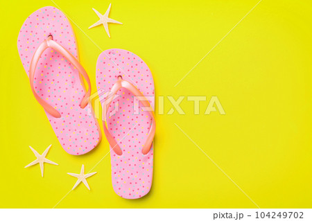 Flat lay composition with flip flops and seashell on colored background. Space for text top view Flat lay composition with flip flops and seashell on colored background. Space for text top view 104249702